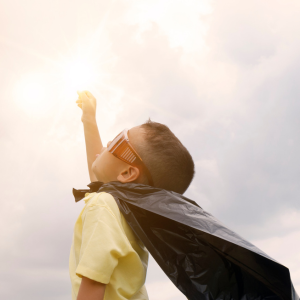 Child wearing a super hero cape