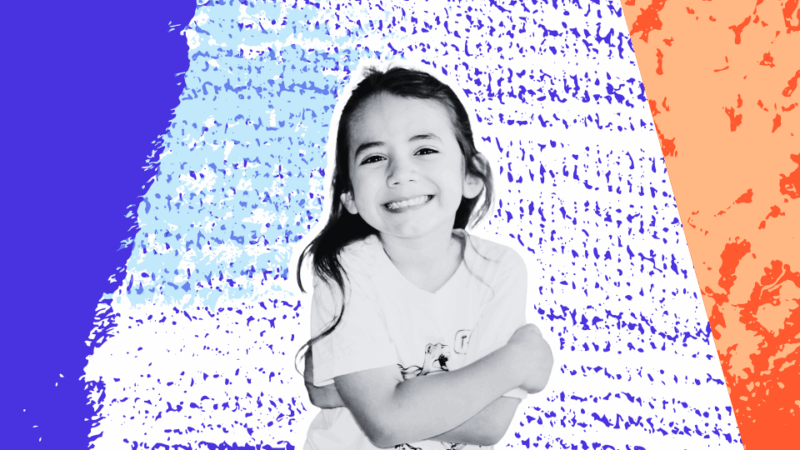 Smiling young girl with long dark hair, arms crossed, standing confidently in front of a colorful, textured background.