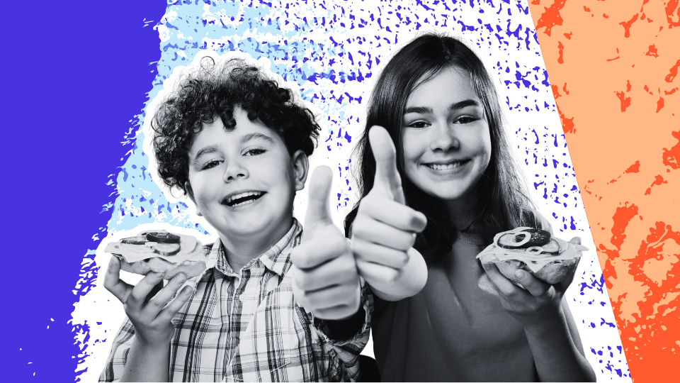 Two smiling kids holding food and giving thumbs up, representing healthy eating and positive mealtime habits.