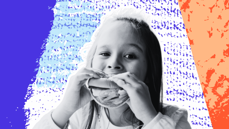 Young child eating a sandwich and enjoying a meal in a relaxed, positive food environment.