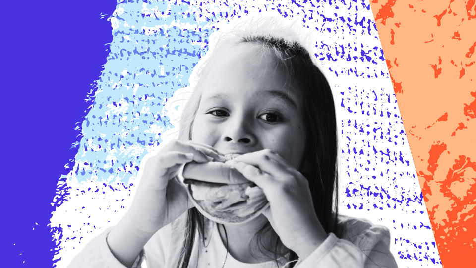 Young child eating a sandwich and enjoying a meal in a relaxed, positive food environment.